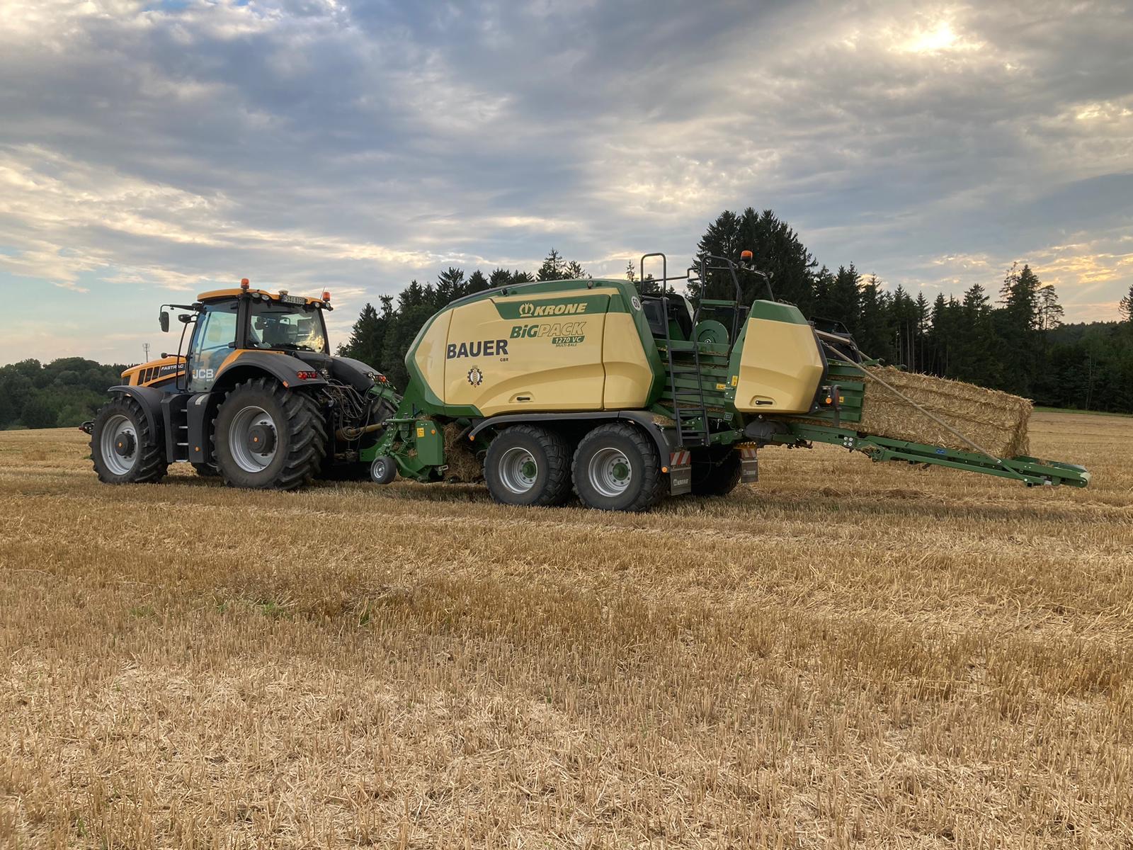 JCB-Traktor mit Krone-BiG-Pack-Quaderballenpresse und Strohballen